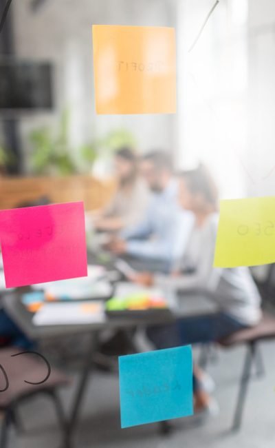 Business people meeting at office and use post it notes to share idea. Brainstorming concept. Sticky note on glass wall.